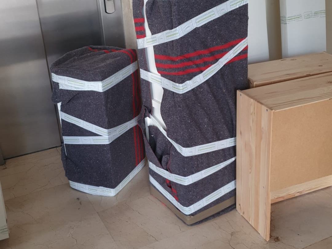 Muebles embalados junto al ascensor, listos para bajar al camión