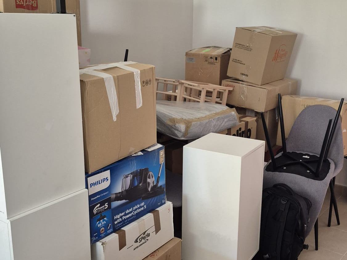 Habitación con cajas y muebles embalados preparados para la mudanza