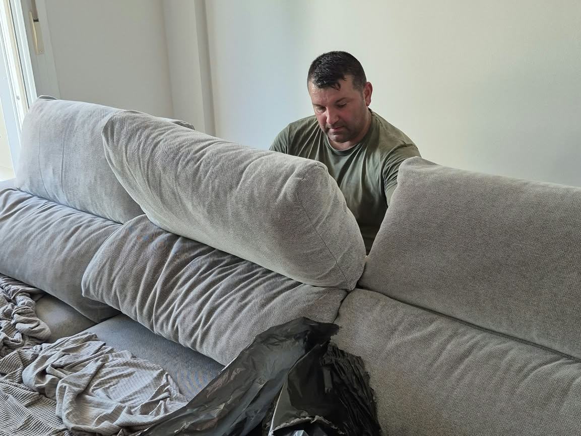 Protegiendo un sofá con plástico antes de moverlo